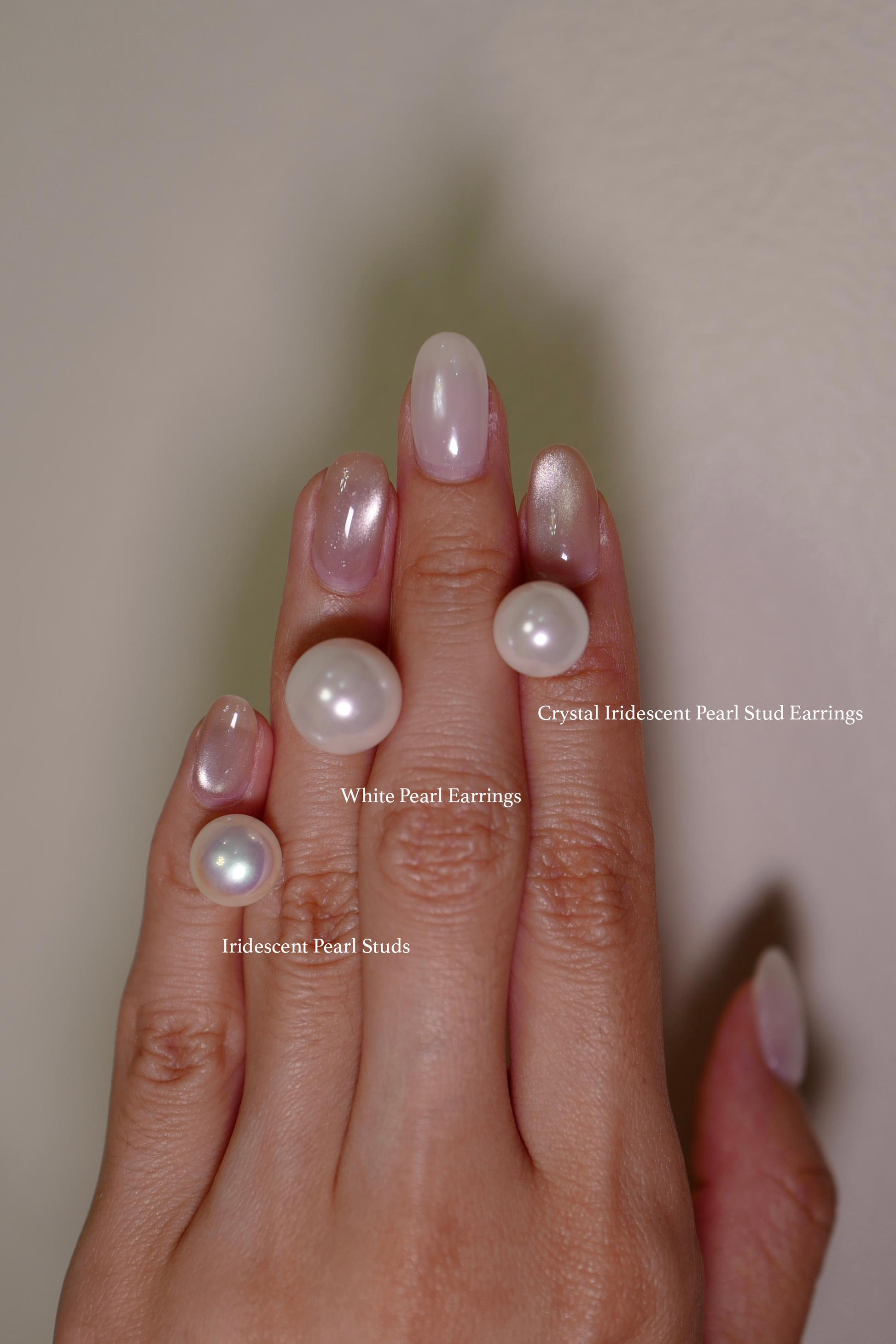 Hand Showing Three Different Pearl Stud Earrings